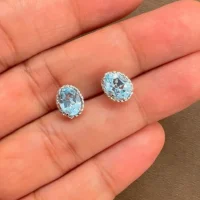 displaying tar studs blue topaz 5x7mm oval on hand