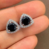 silver studs triangular shaped with 6mm round Black Onyx and cubic zirconia displayed on hand
