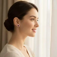 model wearing silver studs triangular shaped with 6mm round Garnet and cubic zirconia
