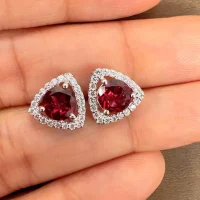 silver studs triangular shaped with 6mm round Garnet and cubic zirconia displayed on hand