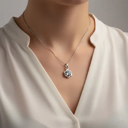 model wearing 5mm round blue topaz with cubic zirconia flower shaped silver pendant