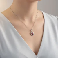 model wearing 5mm round garnet with cubic zirconia flower shaped silver pendant