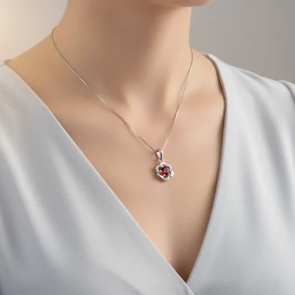 model wearing 5mm round garnet with cubic zirconia flower shaped silver pendant