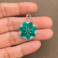 5x7 pear shaped green onyx with cubic zirconia flower shaped silver pendant displayed on hand