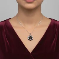 model wearing 5x7 pear shaped black onyx with cubic zirconia flower shaped silver pendant
