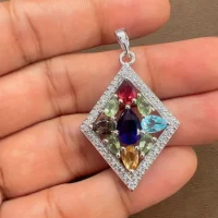 multi gemstone studded silver pendant with cubic zirconia displayed on hand