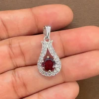 6mm round garnet with cubic zirconia silver pendant displayed on hand