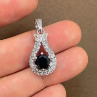 6mm round black onyx with cubic zirconia silver pendant displayed on hand