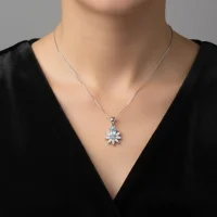 model wearing 5x7 mm pear shaped blue topaz with cubic zirconia silver flower pendant