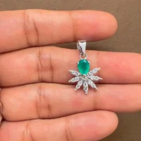 5x7 mm pear shaped green onyx with cubic zirconia silver flower pendant displayed on hand