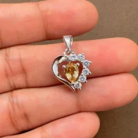 5x7 mm pear shaped citrine with cubic zirconia silver heart shaped pendant displayed on hand