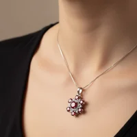 model wearing round flower shaped garnet silver pendant with cubic zirconia
