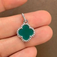 silver pendant clover shaped green onyx displayed on hand