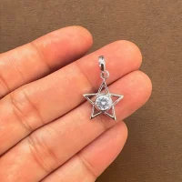 Star shaped silver pendant with cubic zirconia displayed on hand