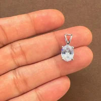 silver pendant single piece 7x9mm oval cubic zirconia displayed on hand