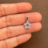 star shaped hollow silver pendant with cubic zirconia displayed on hand