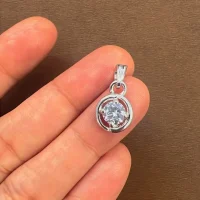 silver pendant with 6mm round single piece cubic zirconia displayed in hand