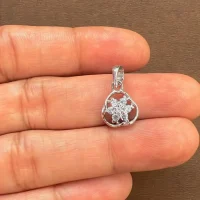 flower shaped seven piece cubic zirconia silver pendant displayed on hand