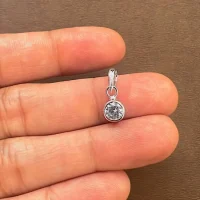 silver pendant with 5mm cubic zirconia in band setting displayed on hand