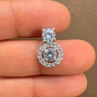 silver pendant with 5mm round cubic zirconia displayed on hand