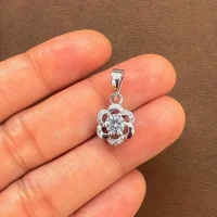 flower shaped 5mm round cubic zirconia silver pendant displayed on hand