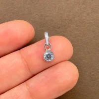 silver pendant with 4mm cubic zirconia in band setting displayed on hand
