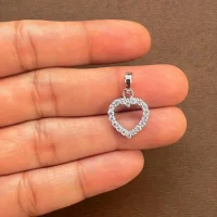 Heart shaped hollow silver pendant with cubic zirconia displaying on hand
