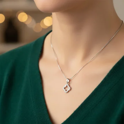 model wearing clover shaped hollow silver pendant with cubic zirconia