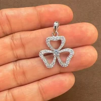 flower shaped silver pendant with 3.5 mm round cubic zirconia displayed on hand