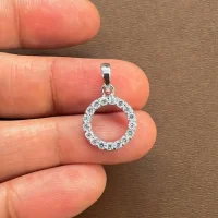 circle shaped hollow silver pendant with cubic zirconia displaying on hand