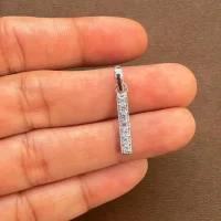 line shaped silver pendant with cubic zirconia displayed on hand