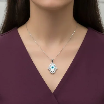 model wearing silver pendant with 9x13mm hamsa shaped cluster evil eye