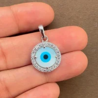 silver pendant with 10mm round shaped cluster evil eye displayed on hand