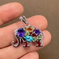 silver pendant elephant design with multi gemstone displayed on hand