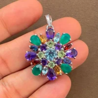 silver pendant round shaped with different shape multi gemstone displayed on hand