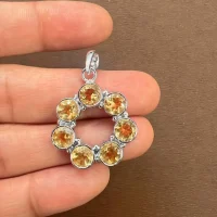 silver pendant round shaped with 6mm round citrine displayed on hand