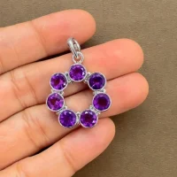silver pendant round shaped with 6mm round amethyst displayed on hand