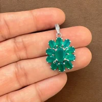 silver pendant flower shaped with green onyx displayed on hand