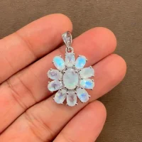 silver pendant flower shaped with rainbow moonstone displayed on hand