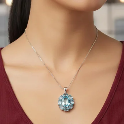 model wearing silver pendant with 10x12 mm and 6x4 mm oval blue topaz gemstone
