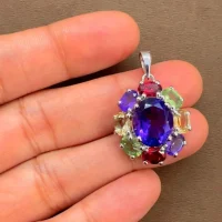 silver pendant with 10x12 mm oval amethyst and 6x4 mm multi gemstone displayed on hand