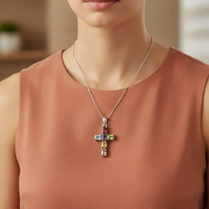 model wearing silver pendant cross design with 4x6mm oval multi gemstone
