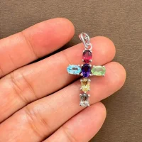 silver pendant cross design with 4x6mm oval multi gemstone displayed on hand