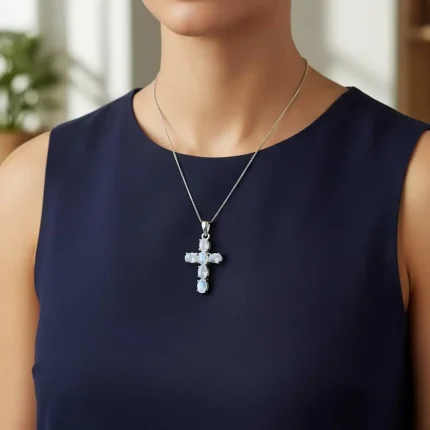 model wearing silver pendant cross design with 4x6mm oval rainbow moonstone