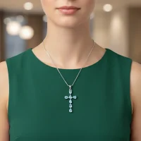 model wearing silver pendant cross design with 4x6mm pear blue topaz