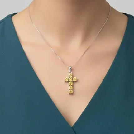 model wearing silver pendant cross design with 5mm round blue topaz