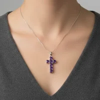 model wearing silver pendant cross design with 5mm round blue topaz