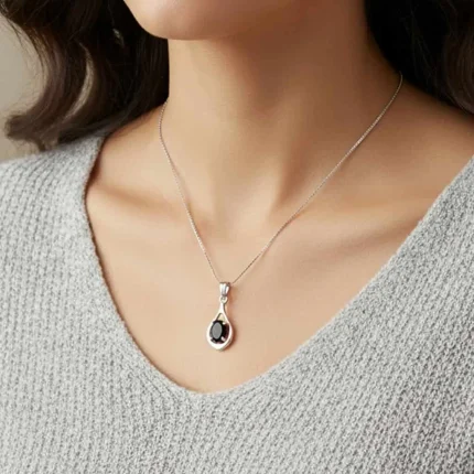 model wearing silver pendant with 5x7 mm oval shaped black onyx