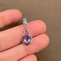silver pendant with 5x7 mm oval shaped brazilian amethyst displayed on hand