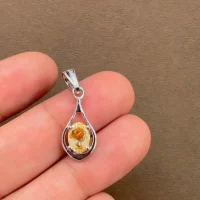 silver pendant with 5x7 mm oval shaped citrine displayed on hand